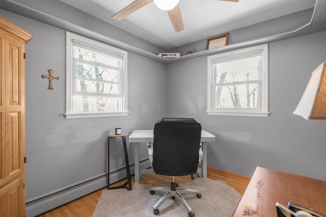 956 10th Ave SE, Forest Lake, MN 55025 - office area featuring a baseboard heating unit, wood finished floors, a ceiling fan, and baseboards