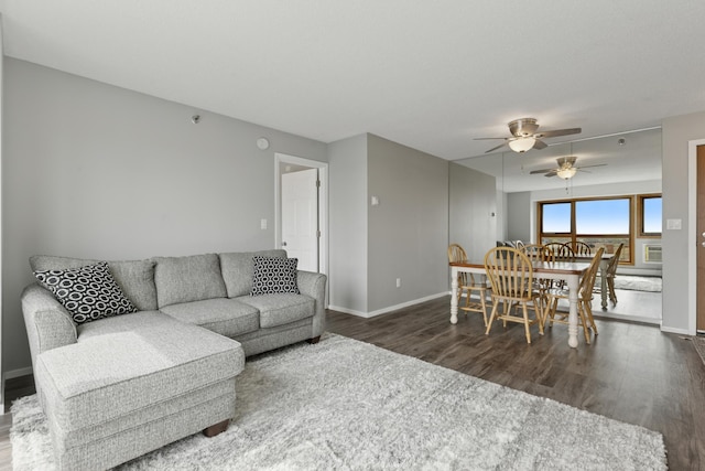 living area featuring baseboards, a ceiling fan, and wood finished floors