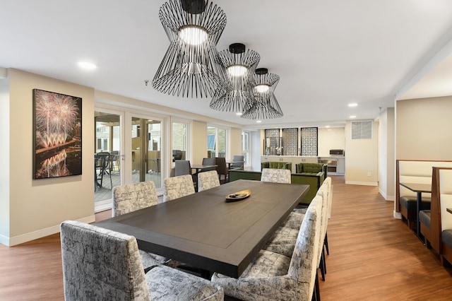 dining room with baseboards, recessed lighting, wood finished floors, and a chandelier