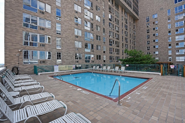 pool with a patio area and fence