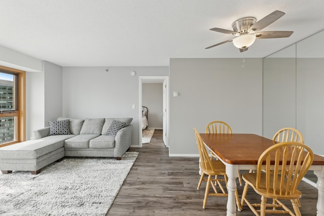 dining room featuring a ceiling fan, baseboards, and wood finished floors