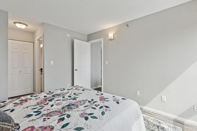 bedroom with baseboards and wood finished floors