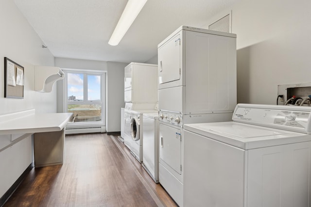 shared laundry area with dark wood-style flooring, independent washer and dryer, stacked washer / dryer, baseboards, and a baseboard heating unit