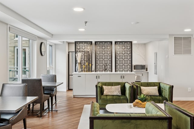living area with light wood finished floors, recessed lighting, and visible vents