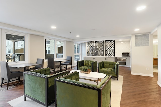living room featuring recessed lighting, baseboards, wood finished floors, and visible vents