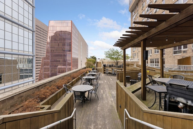 wooden deck with a pergola and outdoor dining space