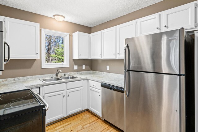 kitchen featuring light countertops, stainless steel appliances, a sink, and light wood-style floors
