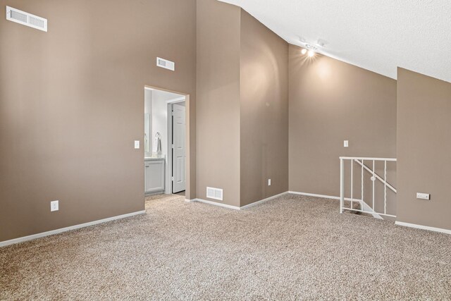 unfurnished room featuring visible vents, baseboards, high vaulted ceiling, and light colored carpet