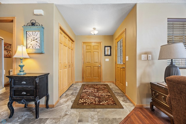 foyer entrance featuring baseboards