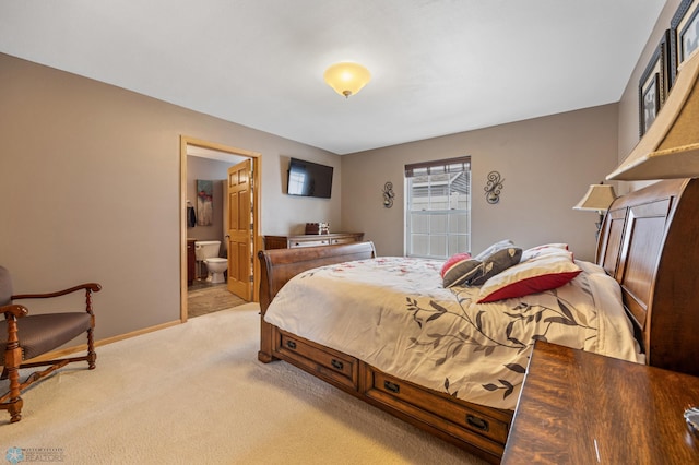 bedroom with light carpet, baseboards, and ensuite bathroom