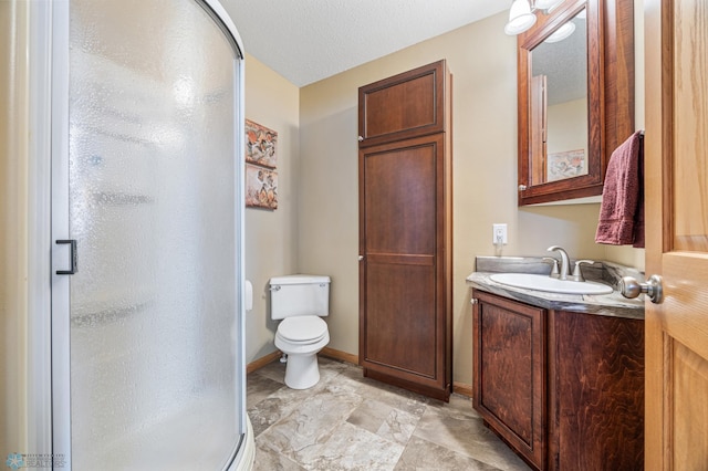 full bath featuring a stall shower, vanity, toilet, and baseboards