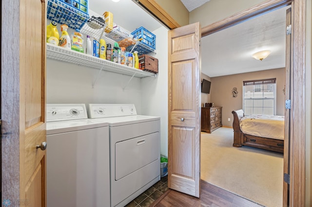 laundry area featuring washer and dryer, dark colored carpet, and dark wood finished floors