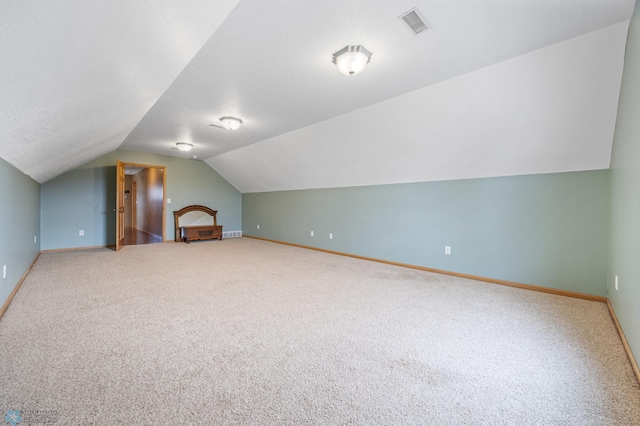 additional living space with carpet floors, vaulted ceiling, and baseboards