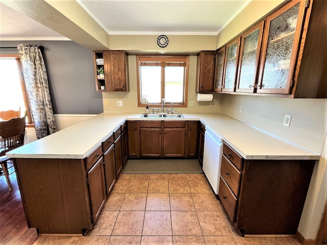 kitchen with a sink, dishwasher, a peninsula, light countertops, and open shelves