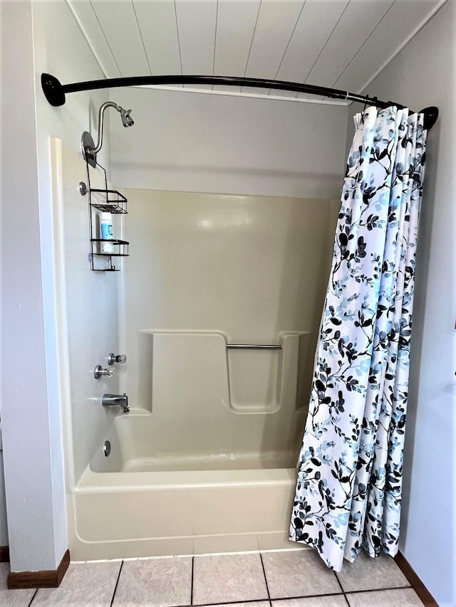 bathroom with baseboards, tile patterned flooring, and shower / tub combo