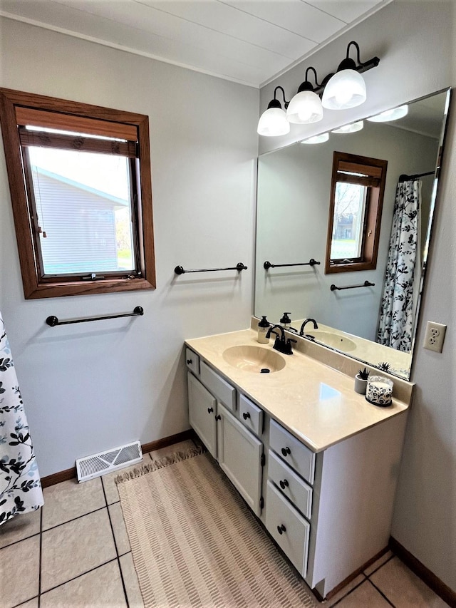 bathroom featuring baseboards, healthy amount of natural light, vanity, and tile patterned floors