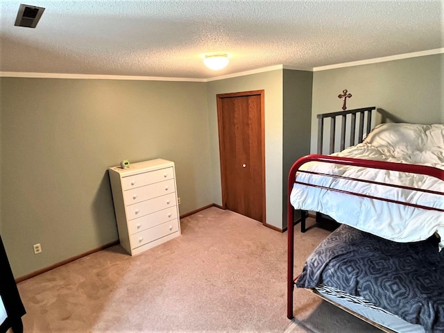 bedroom with ornamental molding, light carpet, a textured ceiling, and baseboards