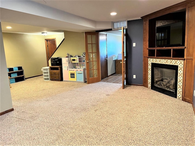 unfurnished living room featuring carpet flooring, recessed lighting, baseboards, and a tile fireplace