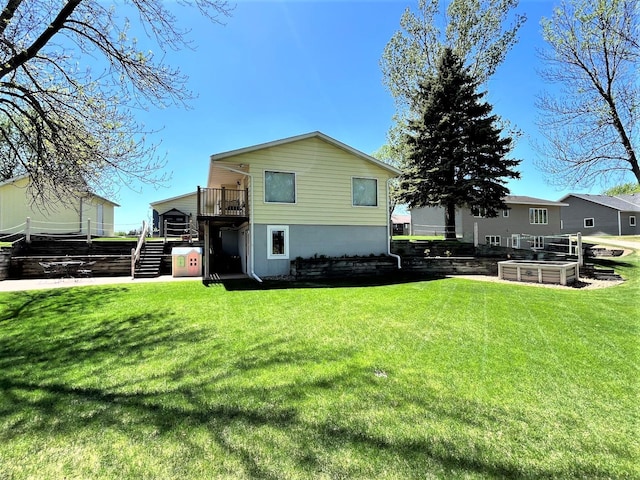 rear view of house featuring stairway and a lawn