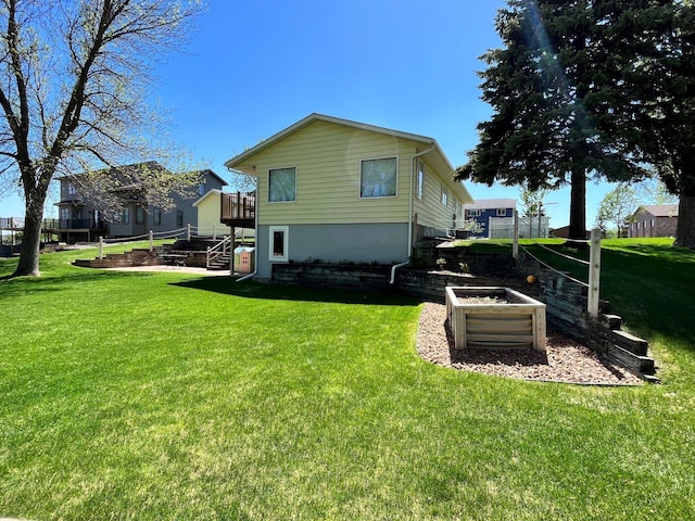 back of property featuring a lawn, a deck, and stairway