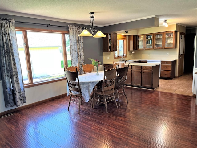 dining area featuring wood finished floors, baseboards, and a textured ceiling