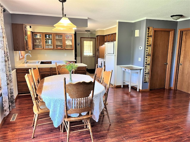 dining room featuring dark wood finished floors and crown molding