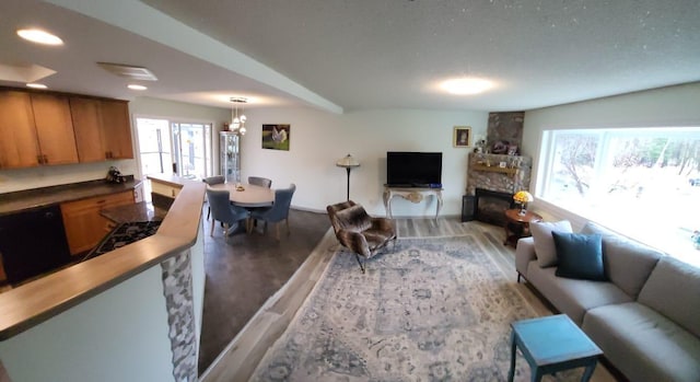 5344 Shady Ln, Canosia Twp, MN 55811 - living area featuring a wealth of natural light, light wood-type flooring, and a stone fireplace