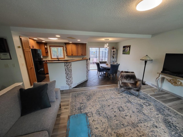 5344 Shady Ln, Canosia Twp, MN 55811 - living area featuring an inviting chandelier, visible vents, a textured ceiling, and dark wood-type flooring