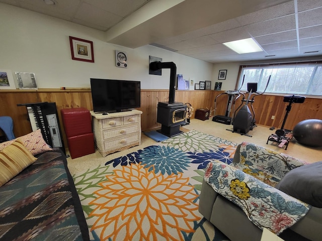 5344 Shady Ln, Canosia Twp, MN 55811 - living area featuring wood walls, a wood stove, carpet flooring, a drop ceiling, and wainscoting