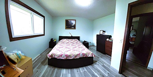 5344 Shady Ln, Canosia Twp, MN 55811 - bedroom with vaulted ceiling, baseboard heating, and wood finished floors