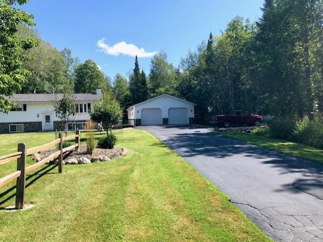 5344 Shady Ln, Canosia Twp, MN 55811 - view of front of house with a chimney, fence, a front lawn, an outdoor structure, and a detached garage