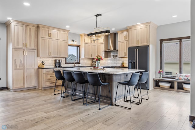 134 Newport Pkwy N, Kindred, ND 58051 - kitchen with light wood finished floors, wall chimney range hood, high end black fridge, and light brown cabinetry