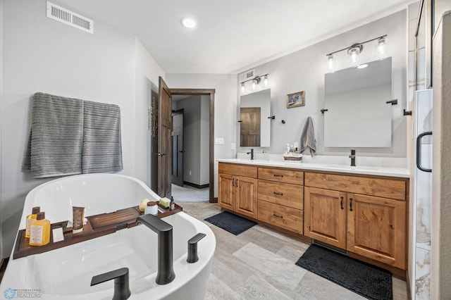 134 Newport Pkwy N, Kindred, ND 58051 - bathroom featuring double vanity, visible vents, a freestanding tub, and a sink