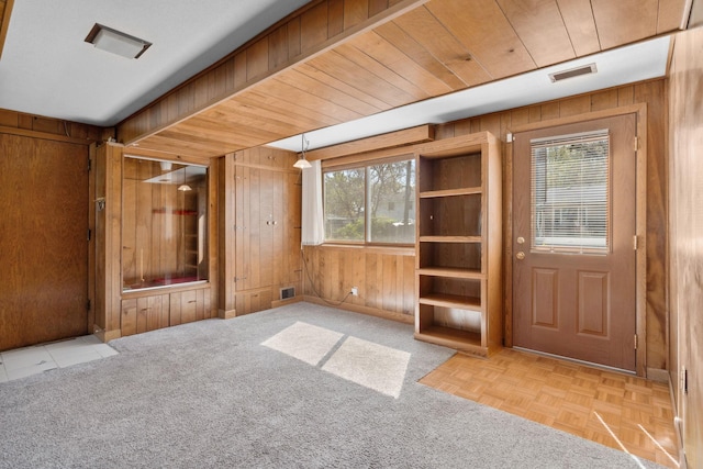 entrance foyer with wooden walls, plenty of natural light, and baseboards