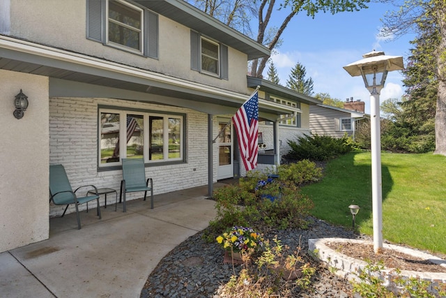 view of front facade with a front lawn, stucco siding, and brick siding