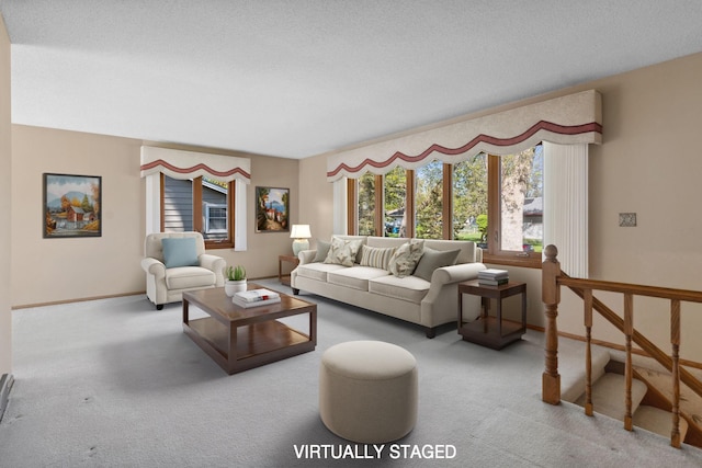 carpeted living area featuring baseboards and a textured ceiling