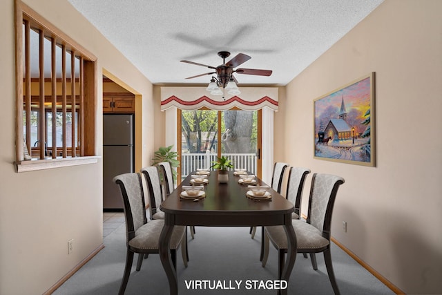 dining space with ceiling fan, light carpet, a textured ceiling, and baseboards