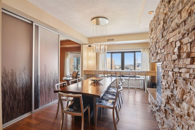1235 Yale Pl Unit 1706, Minneapolis, MN 55403 - dining area with a fireplace, hardwood / wood-style flooring, a textured ceiling, and a chandelier