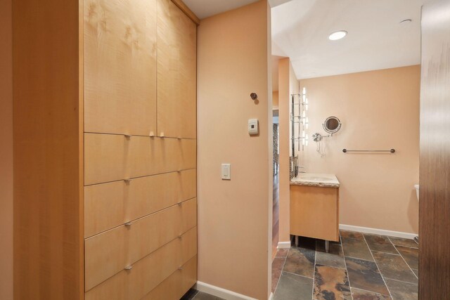1235 Yale Pl Unit 1706, Minneapolis, MN 55403 - bathroom with baseboards, stone tile flooring, and vanity