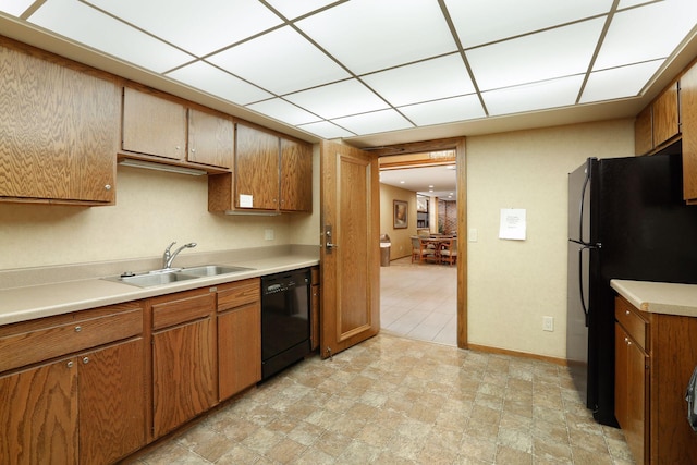 1235 Yale Pl Unit 1706, Minneapolis, MN 55403 - kitchen featuring brown cabinetry, a sink, black appliances, and light countertops
