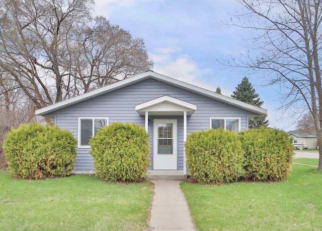 bungalow-style home with a front lawn