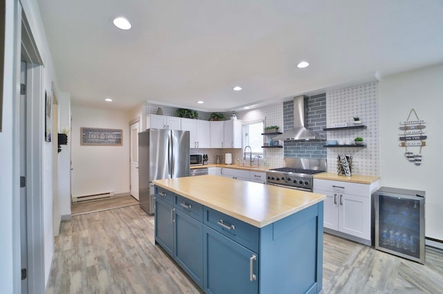 kitchen featuring wall chimney range hood, baseboard heating, open shelves, stainless steel appliances, and white cabinetry