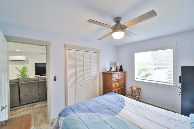 bedroom featuring a closet, a ceiling fan, and an AC wall unit
