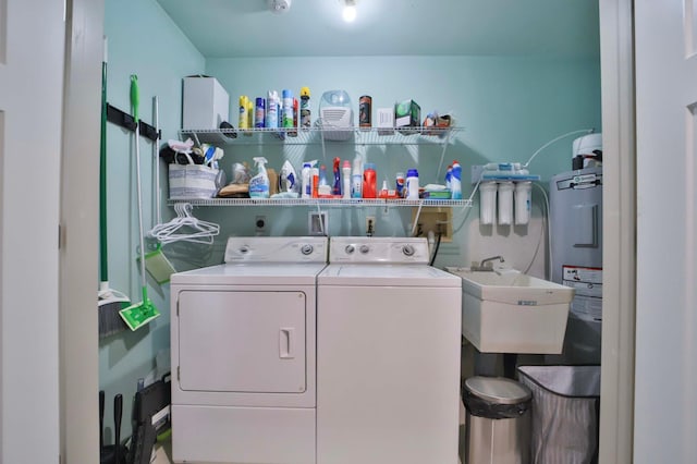 laundry room featuring a sink, water heater, laundry area, and washing machine and clothes dryer