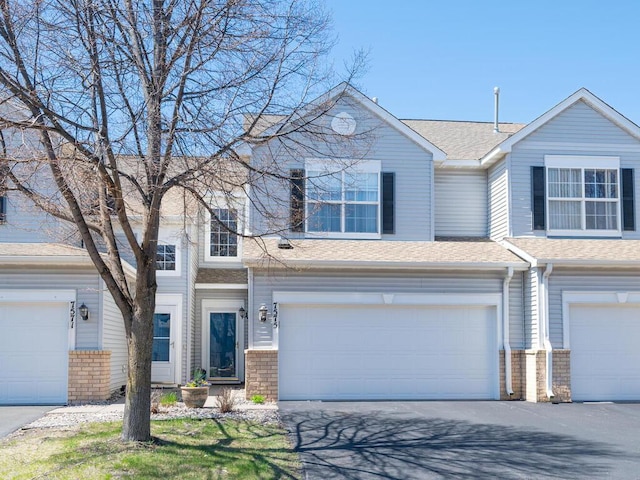 7575 Derby Ln, Shakopee, MN 55379 - view of property with brick siding, roof with shingles, a garage, and driveway