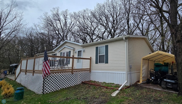 rear view of property with a wooden deck and a detached carport