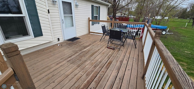 deck featuring a lawn and outdoor dining space