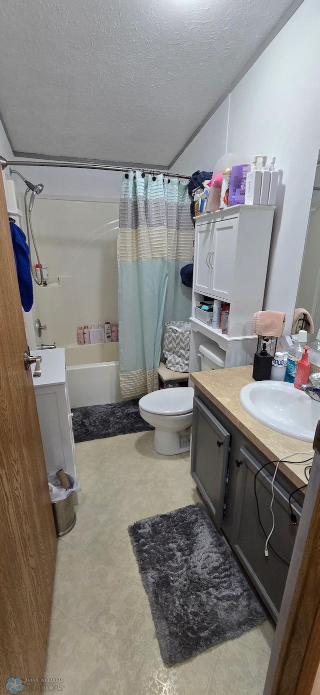 bathroom featuring vanity, toilet, a textured ceiling, and shower / tub combo