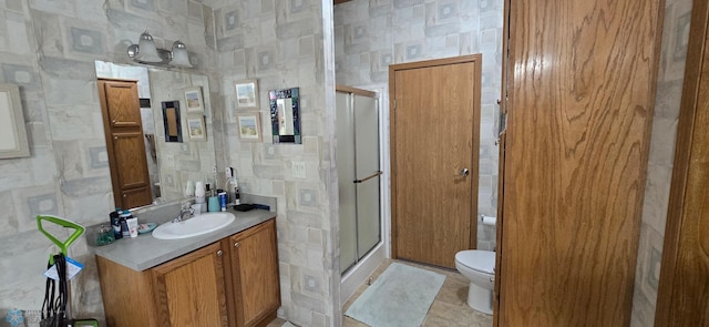 bathroom with vanity, toilet, and a shower stall