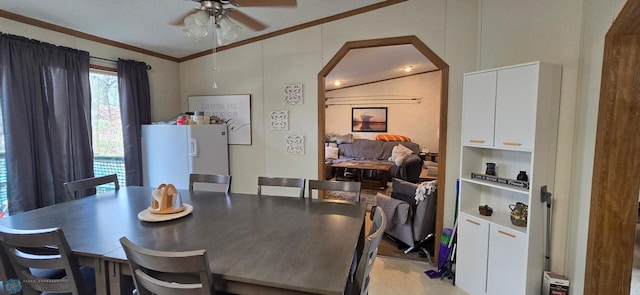 dining area featuring arched walkways, ornamental molding, a ceiling fan, and lofted ceiling